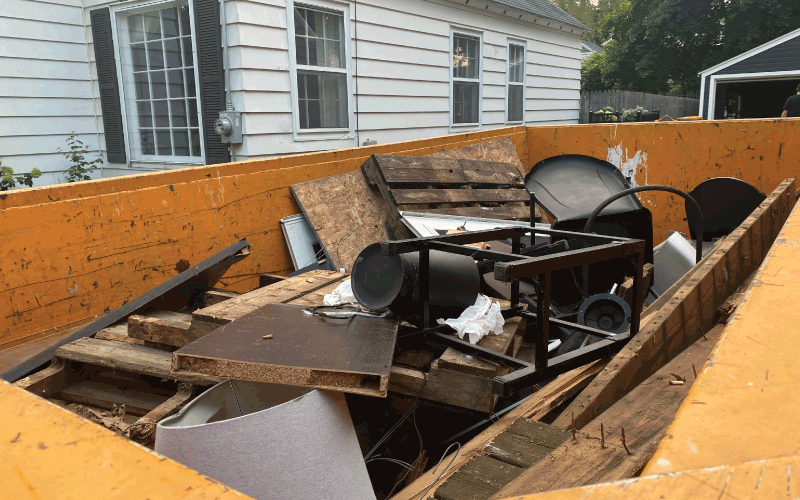 dumpster with household junk inside