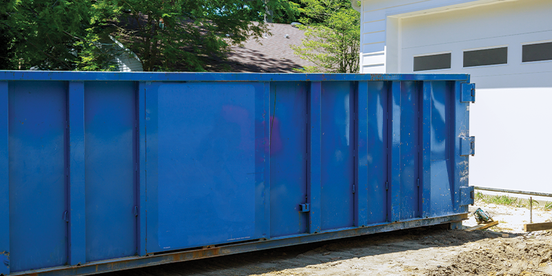 blue temporary dumpster in driveway